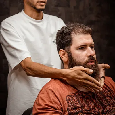 Barber gebruikt open scheermes en warme handdoek voor traditionele scheerbeurt bij City Center Barbershop
